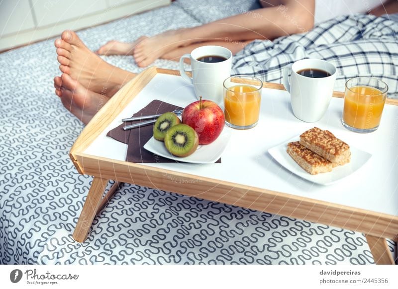 Gesundes Frühstück auf Tablett und Paar Beine im Hintergrund Frucht Apfel Saft Kaffee Lifestyle Glück Erholung Freizeit & Hobby Schlafzimmer Frau Erwachsene
