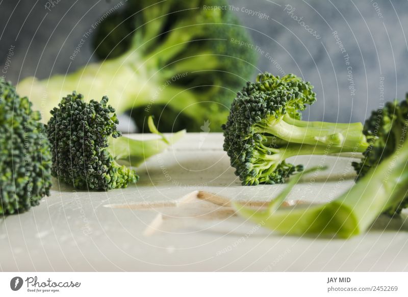 Kleine Stücke roher Brokkoli auf weißem Holz, Nahaufnahme Lebensmittel Gesunde Ernährung Speise Spielfigur Gesundheit Detailaufnahme frisch grün Diät Gemüse