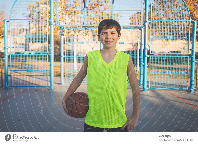 Teenager-Junge hält einen Basketball auf einem Platz. Lifestyle Erholung Spielen Sport Ball Telefon PDA Mensch maskulin Junger Mann Jugendliche Erwachsene 1