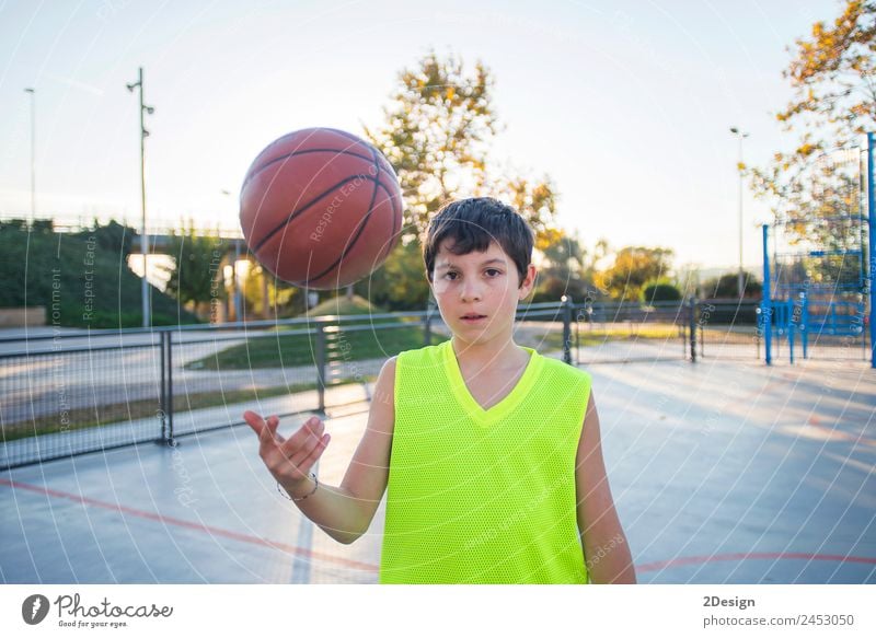 Schöne junge Teenager-Modell trägt eine gelbe ärmellose und hält den Ball auf dem Platz Lifestyle Glück Gesicht Erholung Freizeit & Hobby Spielen Sport Erfolg