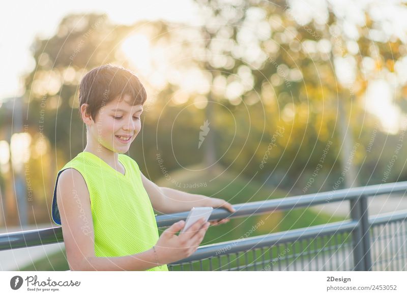 Teenager lächelnd, der sein Smartphone auf einem Basketballplatz aussieht. Lifestyle Stil Freude Glück Freizeit & Hobby Dekoration & Verzierung Schule Studium