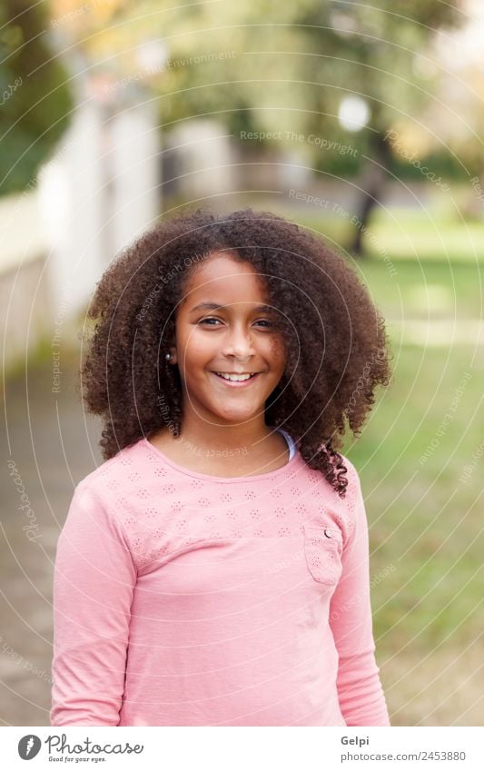 Süßes afroamerikanisches Mädchen lächelnd auf der Straße mit Afrohaar. Freude Glück schön Winter Kind Mensch Kleinkind Kindheit Natur Park Afro-Look Lächeln