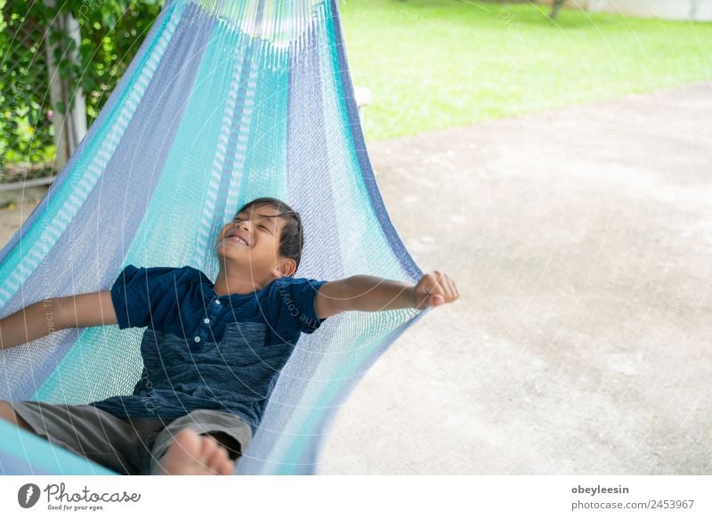 Der kleine Junge, der in der Hängematte sitzt und so glücklich ist. Lifestyle Freude Glück Erholung Freizeit & Hobby Ferien & Urlaub & Reisen Sommer Garten Kind