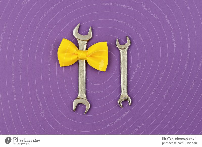 Zwei große und kleine Schraubenschlüssel mit gelber Schleife auf violett. Lifestyle Design Glück Dekoration & Verzierung Feste & Feiern Geburtstag Werkzeug