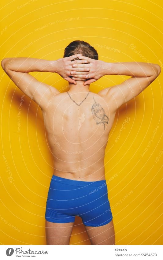 junger Mann mit einer Tätowierung auf dem Rücken in farbigen Shorts. Lifestyle Körper Haut Wellness Sport Fitness Sport-Training Sportler Mensch maskulin
