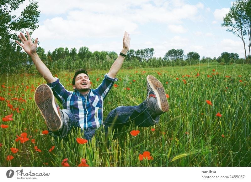 Junger glücklicher Mann, der Spaß auf einem Feld mit grünem Weizen hat. Lifestyle Freude Gesundheit Wellness Leben Zufriedenheit Mensch maskulin Junger Mann