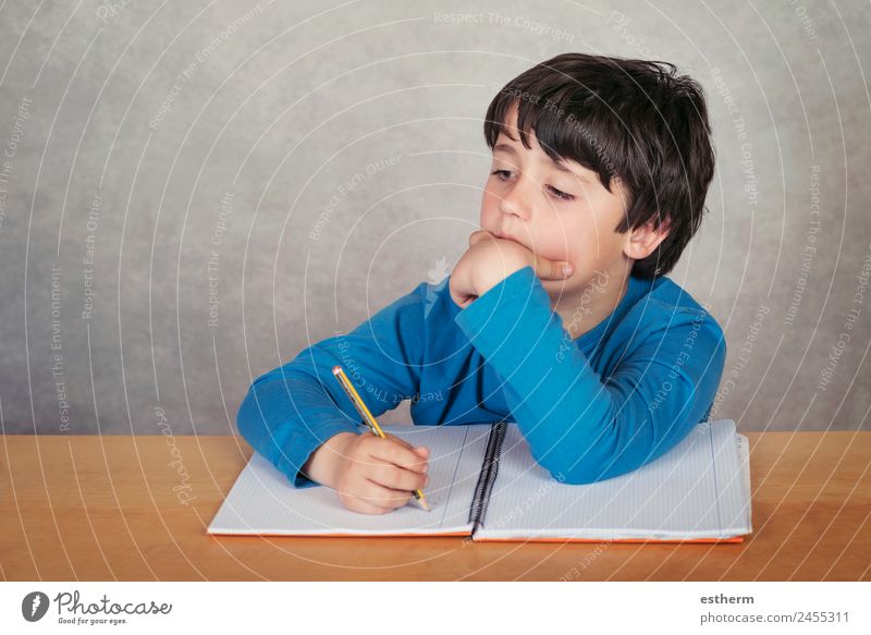 trauriger und nachdenklicher Junge mit einem Buch auf grauem Hintergrund Lifestyle lesen Kind Schule lernen Mensch maskulin Kleinkind Kindheit 1 8-13 Jahre