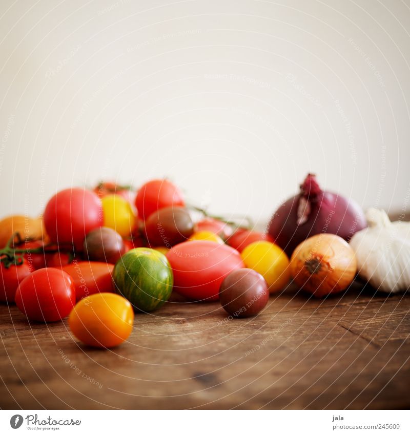 sommergemüse Lebensmittel Gemüse Tomate Zwiebel Knoblauchknolle Gesundheit lecker gelb grün rot Holztisch Farbfoto Innenaufnahme Menschenleer Textfreiraum oben