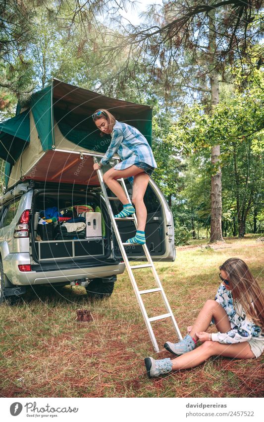 Frau, die die Leiter vom Zelt über das Auto steigt. Lifestyle Freude Glück Erholung Freizeit & Hobby Ferien & Urlaub & Reisen Ausflug Abenteuer Camping Sommer