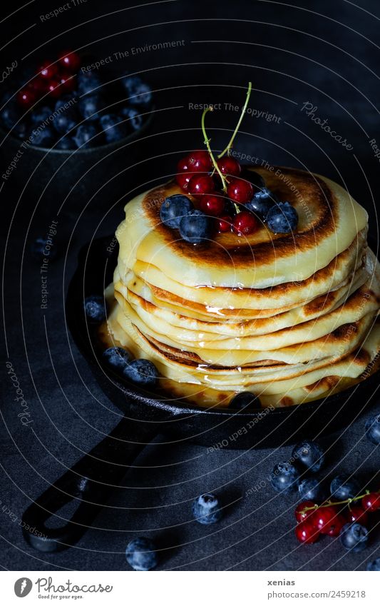 Kleine Pfannkuchen mit Ahornsirup in schwarzer Pfanne im moody style Johannisbeeren Lebensmittel Frucht Blaubeeren Zucker pancakes Ernährung Frühstück Büffet