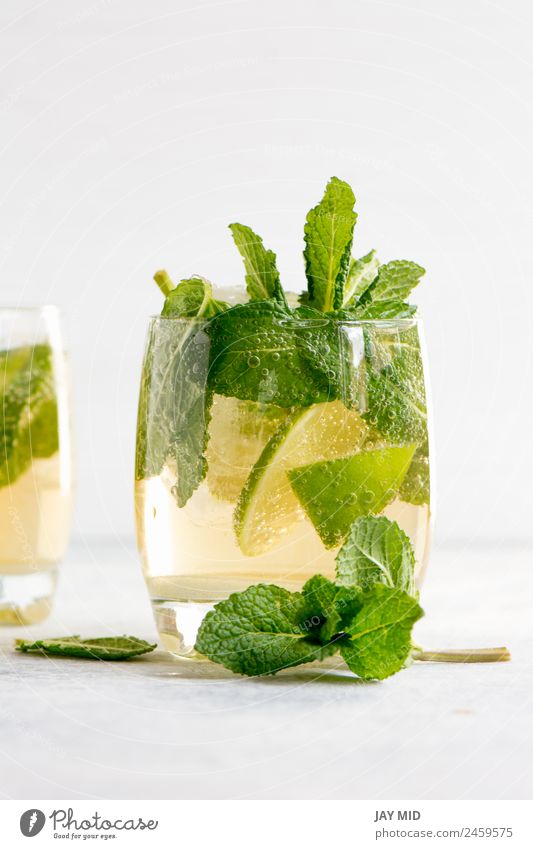 Mojito-Cocktail mit Rum, Limette und Soda Frucht Kräuter & Gewürze Getränk Erfrischungsgetränk Limonade Saft Alkohol Longdrink Glas exotisch Sommer Tisch Blatt