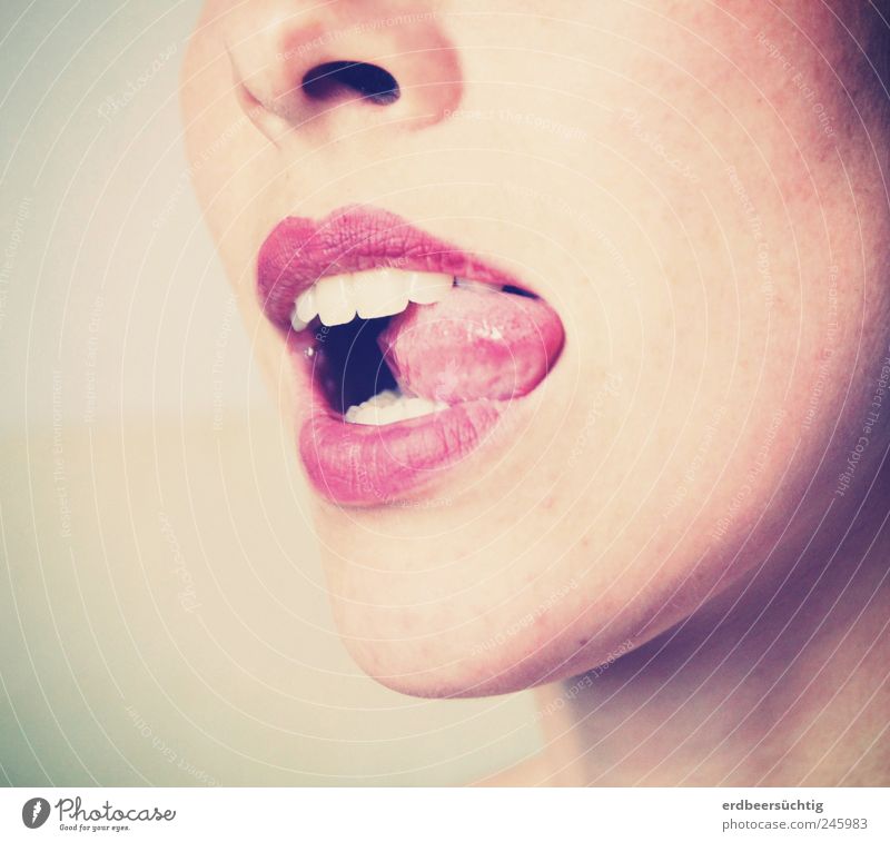 Geschmackstest - Zunge im Mundwinkel von geschminkten, weiblichen Lippen, die weiße Zähne preisgeben schön Haut Gesicht Lippenstift Wohlgefühl Zufriedenheit
