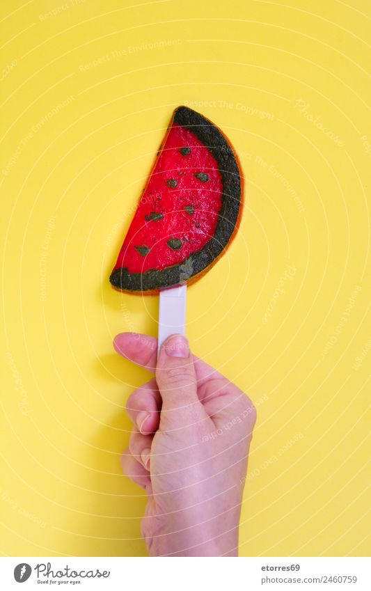 Hand mit Wassermelonen-Popsicle auf gelbem Hintergrund. Draufsicht Lebensmittel Frucht Dessert Speiseeis Süßwaren Essen Bioprodukte rot Sommer Eis Snack kalt