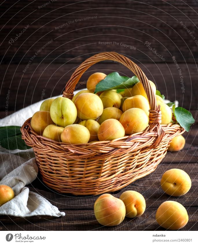 Reife Aprikosen in einem braunen Weidenkorb Frucht Ernährung Vegetarische Ernährung Diät Tisch Essen frisch natürlich saftig gelb Farbe Korb Ackerbau