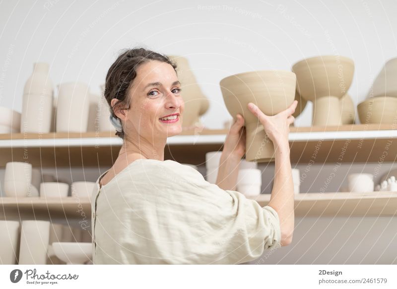 Schöner Keramikerbesitzer, der auf die Kamera schaut, während er lächelt. Topf Freizeit & Hobby Handarbeit Arbeit & Erwerbstätigkeit Beruf Handwerker