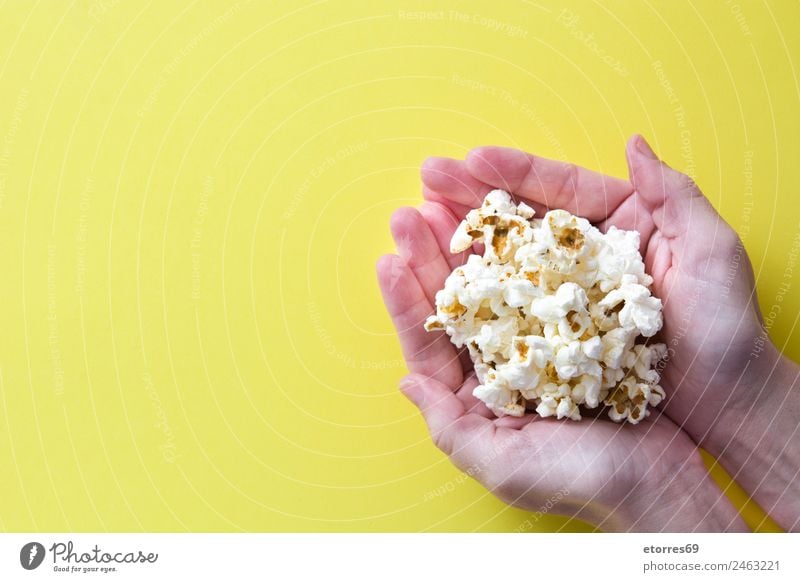 Frau mit Popcorn in der Hand auf gelbem Hintergrund. Kopierbereich Lebensmittel Ernährung Essen Bioprodukte Vegetarische Ernährung Diät Fastfood Fingerfood