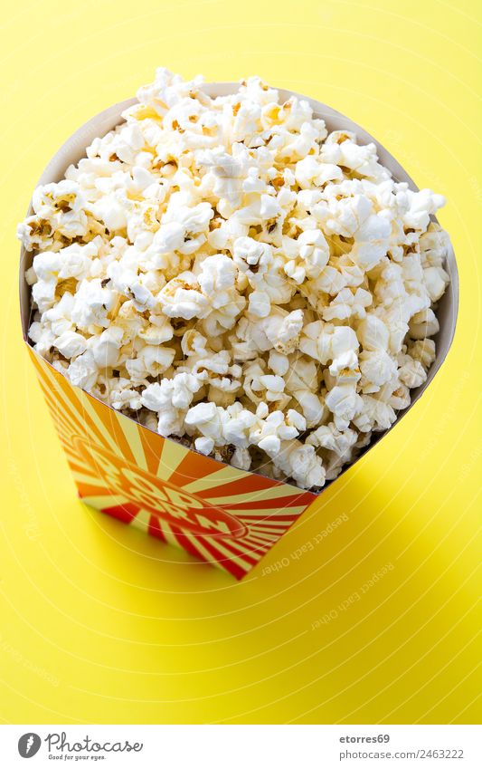 Gestreifte Box mit Popcorn auf gelbem Hintergrund. Lebensmittel Ernährung Essen Fingerfood weiß "Popcorn Kino Salz Butter Snack Mais lecker vereinzelt gestreift