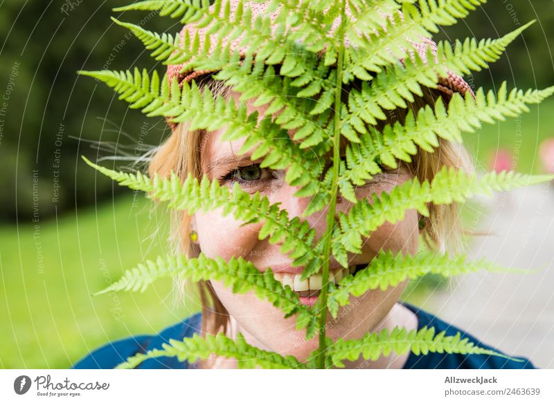 Portrait einer jungen Frau mit Farn im Gesicht Tag Schönes Wetter Natur grün Baum Wald Berge u. Gebirge Idylle Ferien & Urlaub & Reisen Reisefotografie wandern