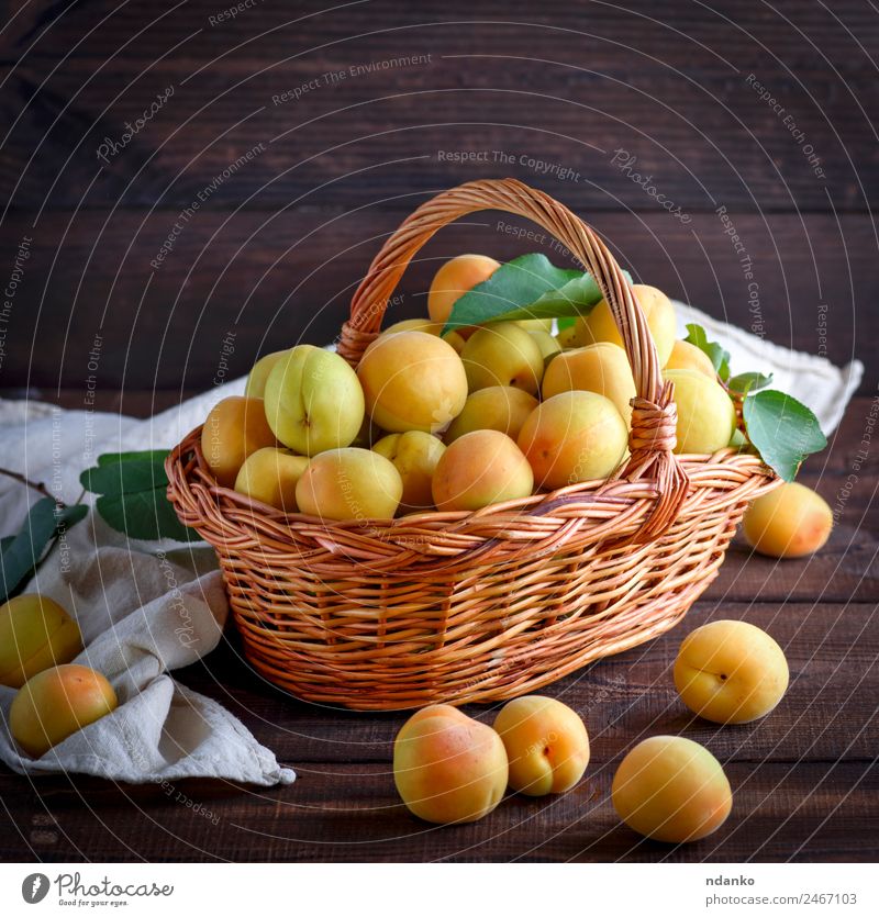 Aprikosen in einem braunen Weidenkorb Frucht Ernährung Vegetarische Ernährung Diät Tisch Natur Blatt Holz frisch lecker natürlich saftig gelb Farbe Korb