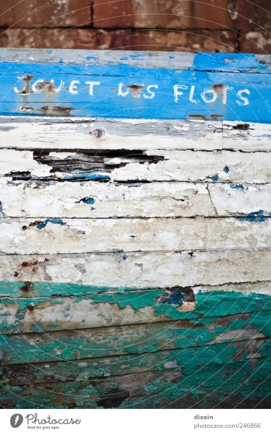 Spielball der Wellen Schifffahrt Fischerboot Wasserfahrzeug Bootslack Schiffsrumpf Schiffswrack alt kaputt Vergänglichkeit Lack abblättern Schriftzeichen