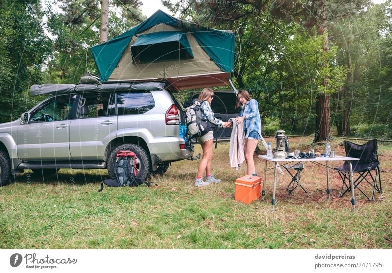 Junge Frauen auf dem Campingplatz packen Decke zum Wandern Lifestyle Freude Glück Erholung Freizeit & Hobby Ferien & Urlaub & Reisen Ausflug Abenteuer Sommer