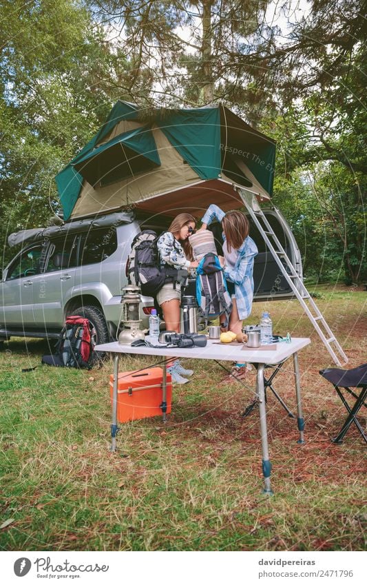 Junge Frauen auf dem Campingplatz, die eine Decke im Rucksack packen. Lifestyle Freude Glück Erholung Freizeit & Hobby Ferien & Urlaub & Reisen Ausflug