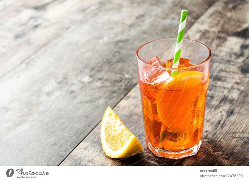 Aperol Schorle Cocktail Getränk Erfrischungsgetränk Alkohol Spirituosen Longdrink Glas Sommer Sommerurlaub gut kalt süß orange Holztisch Eis Farbfoto