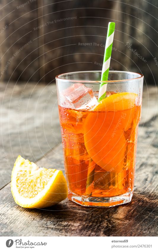 Aperol Schorle Cocktail Getränk Erfrischungsgetränk Alkohol Longdrink Glas gut kalt saftig süß Orange Sommer Frucht Holztisch geschmackvoll Italienisch Farbfoto