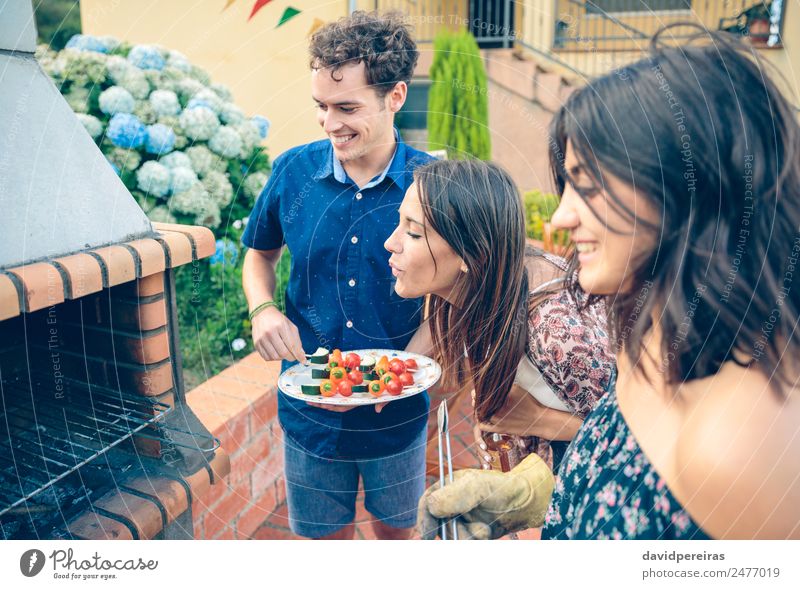 Gruppe von Freunden, die bei einem Sommergrill kochen. Gemüse Mittagessen Alkohol Bier Teller Flasche Lifestyle Freude Glück Freizeit & Hobby Garten sprechen