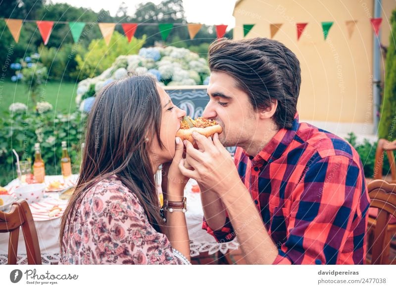 Lustiges junges Paar beim Essen eines amerikanischen Hotdogs Wurstwaren Brot Brötchen Mittagessen Fastfood Lifestyle Freude Glück Sommer Frau Erwachsene Mann