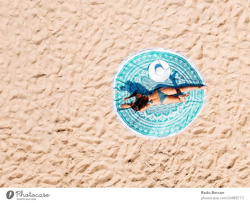 Top Luftdrohne Ansicht der Frau im Badeanzug Bikini Entspannen und Sonnenbaden auf runden türkisfarbenen Strandtüchern in der Nähe des Ozeans Aussicht Handtuch