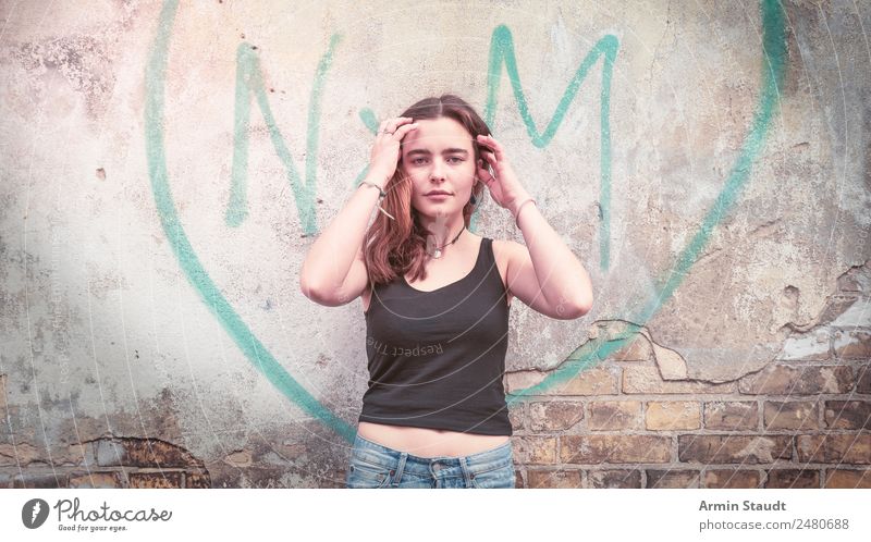 Porträt einer jungen Frau vor einem Graffiti-Herzen auf einer Wand Lifestyle Stil Design Freude Glück schön Leben harmonisch Wohlgefühl Zufriedenheit
