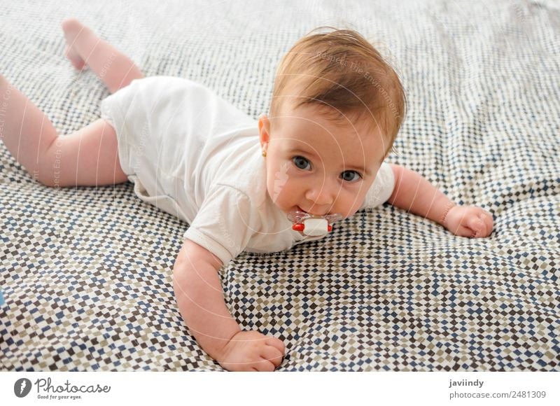 Glückliches Mädchen im Alter von vier Monaten, auf dem Bett mit Schnuller. schön Gesicht Leben Kind Mensch Baby Kindheit 1 0-12 Monate Lächeln schlafen klein