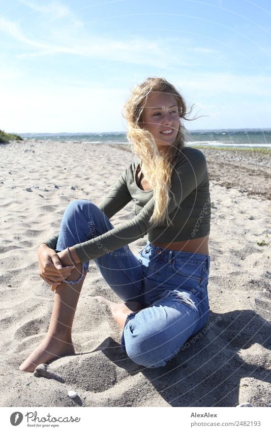 Junge Frau am Ostseestrand Glück Wohlgefühl Sommer Sommerurlaub Sonne Strand Jugendliche 18-30 Jahre Erwachsene Natur Landschaft Schönes Wetter Wind Jeanshose