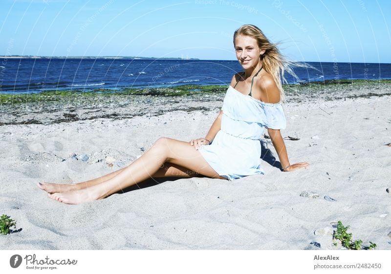 Junge, schlanke, langebeinige Frau am Ostseestrand in einem Sommerkleid Lifestyle schön Leben Wohlgefühl Sommerurlaub Sonne Sonnenbad Strand Meer Junge Frau