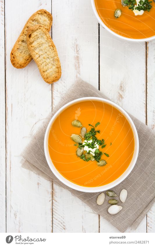 Kürbissuppe in weißer Schale auf weißem Holztisch Lebensmittel Gemüse Suppe Eintopf Ernährung Bioprodukte Vegetarische Ernährung Schalen & Schüsseln Gesundheit