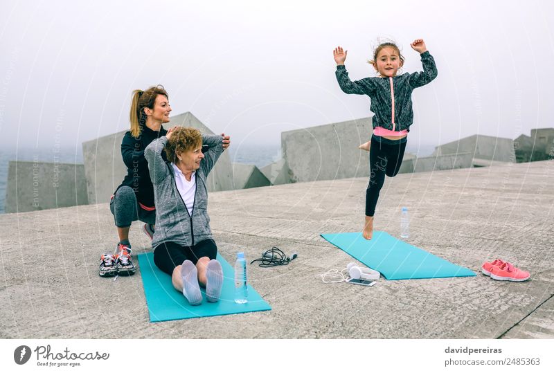 Mädchen springen, während Frauen trainieren. Flasche Lifestyle Glück Wellness Sport Kind Telefon Mensch Erwachsene Mutter Großmutter Familie & Verwandtschaft