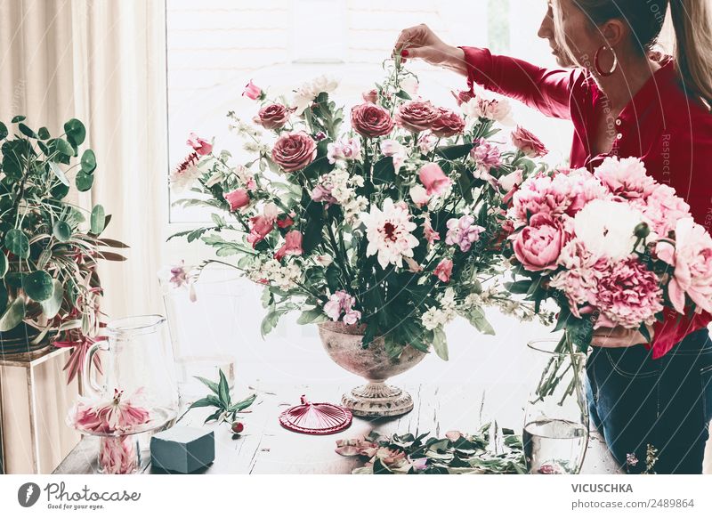Frau dekoriert großen Blumenstrauß mit Rosen in Vase Lifestyle Reichtum Stil Design Freizeit & Hobby Häusliches Leben Haus Traumhaus Innenarchitektur