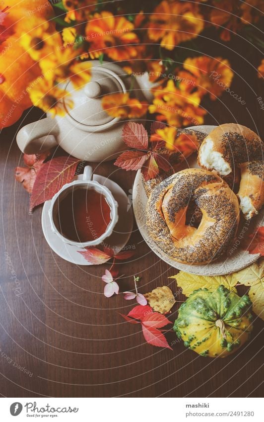 Draufsicht auf das gemütliche Herbstfrühstück auf dem Tisch im Landhaus Frühstück Getränk Tee Topf Lifestyle Blatt Holz braun Geborgenheit fallen Bagel essen
