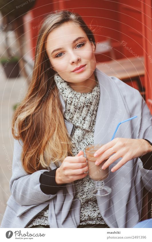 hübsche junge Frau trinkt Kaffee im Freien im Café Junge Frau Jugendliche Erwachsene 18-30 Jahre blond trinken laufen Jahreszeiten Herbst Mantel Mode Behaarung