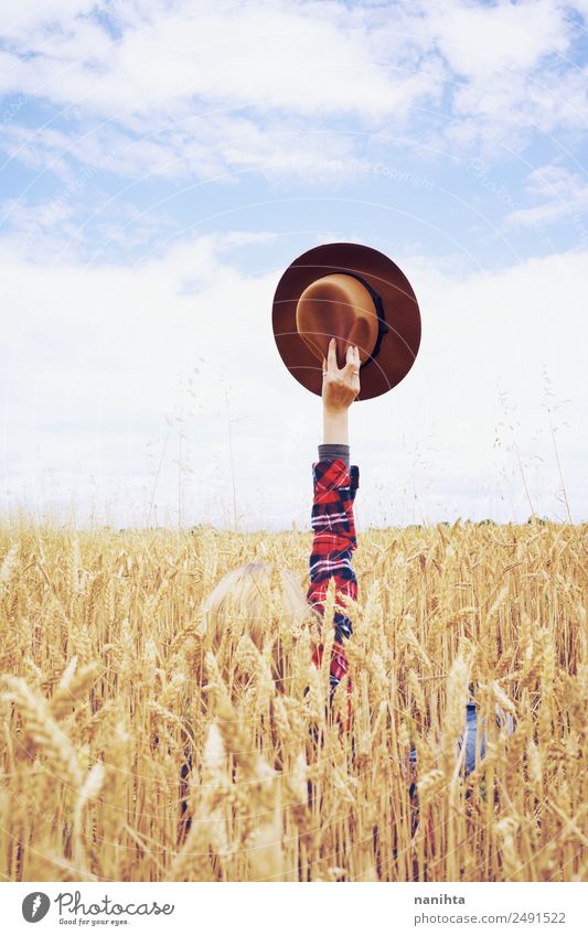 Hand hält einen Cowboyhut in einem Weizenfeld. Getreide Design Freude Freiheit Sommerurlaub Landwirtschaft Forstwirtschaft Arme Umwelt Natur Landschaft Herbst