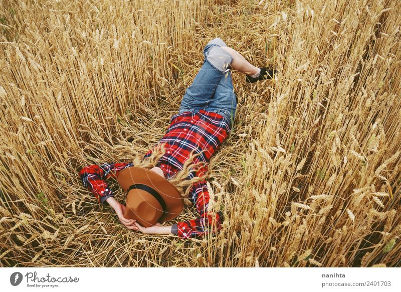 Junge Frau schläft auf einem Weizenfeld. Lifestyle Stil Design Freude Wellness Erholung Ferien & Urlaub & Reisen Abenteuer Freiheit Sommer Sommerurlaub