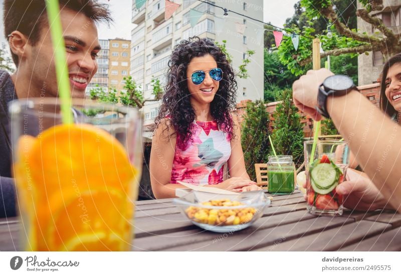 Junge Frau im Gespräch mit Freunden an einem Sommertag Gemüse Frucht Getränk Lifestyle Freude Glück schön Freizeit & Hobby Ferien & Urlaub & Reisen Garten Tisch