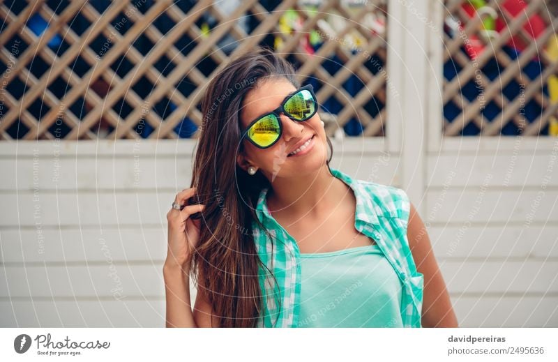 Frau mit Sonnenbrille schaut auf die Kamera über dem Gartenzaun. Lifestyle Freude Glück schön Gesicht Freizeit & Hobby Sommer Spiegel Mensch Erwachsene Finger