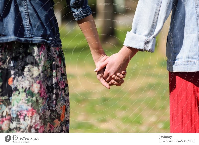Zwei junge Frauen beim Gehen, die ihre Hände im Freien halten. Lifestyle Freude Glück schön Mensch feminin Junge Frau Jugendliche Erwachsene Freundschaft Paar