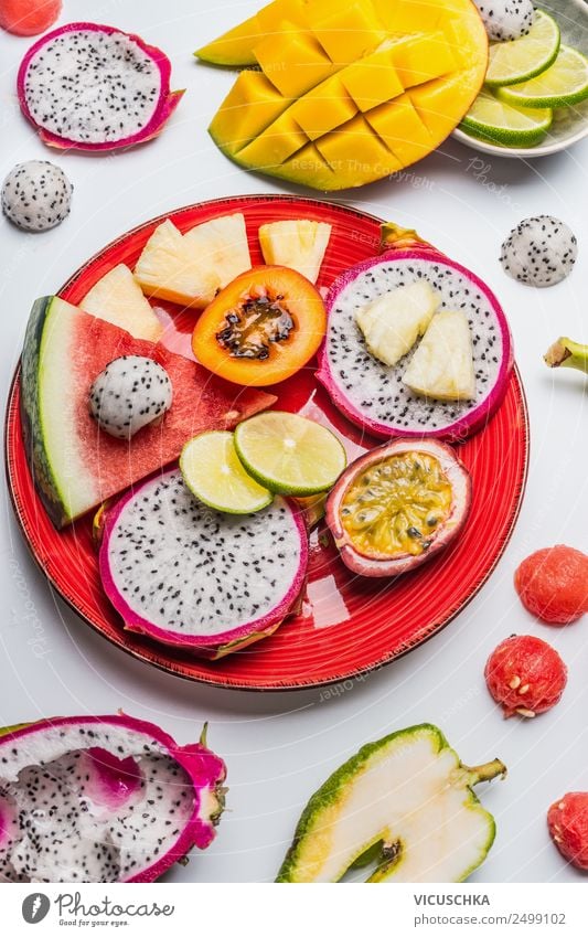 Verschiedene tropische Früchte auf roter Platte Lebensmittel Frucht Dessert Ernährung Frühstück Bioprodukte Vegetarische Ernährung Diät Teller Stil Design