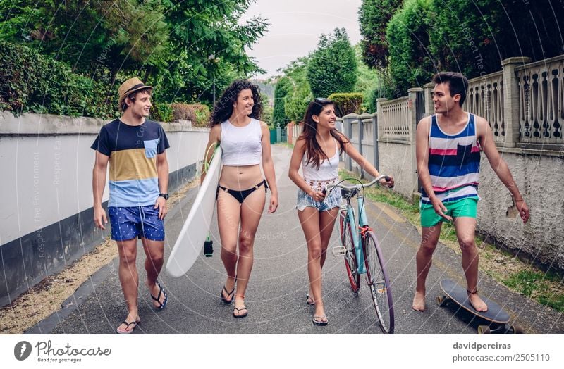 Glückliche junge Menschen, die am Sommertag die Straße entlang gehen. Lifestyle Freude Erholung Freizeit & Hobby Ferien & Urlaub & Reisen Sport Frau Erwachsene