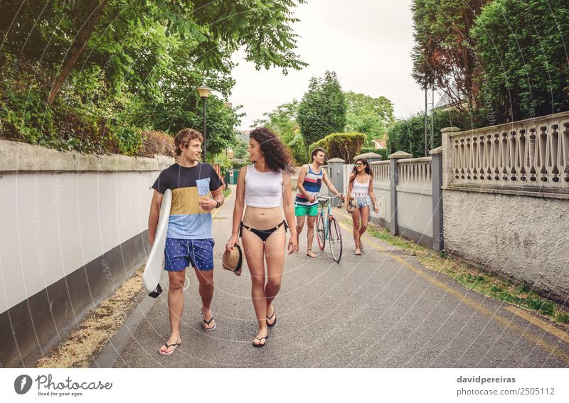 Glückliche junge Menschen, die am Sommertag die Straße entlang gehen. Lifestyle Freude Freizeit & Hobby Ferien & Urlaub & Reisen Sport Frau Erwachsene Mann