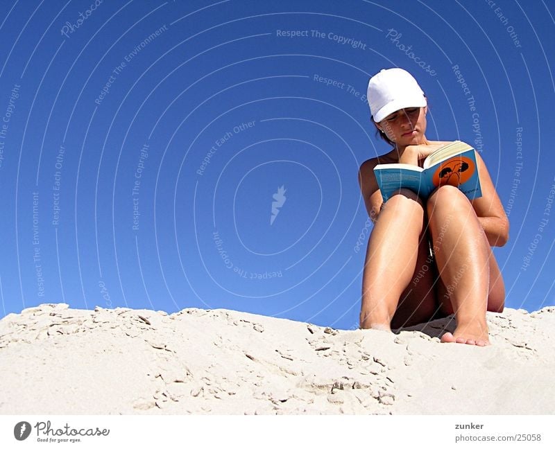 Anleitung zum Unschuldigsein Frau nackt lesen Buch Strand Baseballmütze Himmel Sand Haut blau Schirmmütze