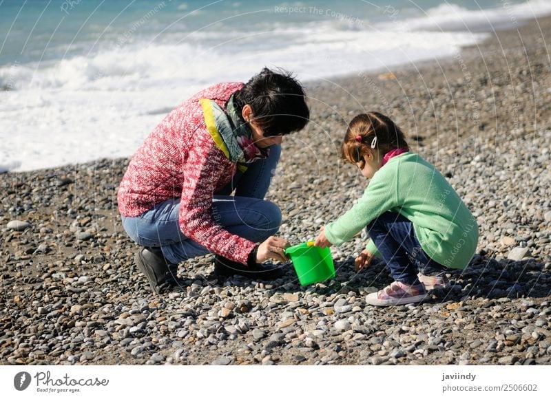 Mutter und kleine Tochter haben im Winter Spaß am Strand. Ferien & Urlaub & Reisen Kind Mensch Mädchen Junge Frau Jugendliche Erwachsene Eltern